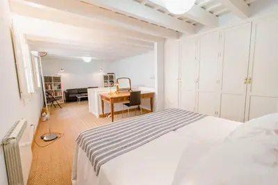 a white bedroom with a bed and a desk at Apartamentos La Botanica, Cadiz in Cádiz