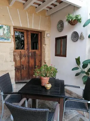 a patio table with chairs and a door with a plant at Apartamentos El Patio Andaluz in Jerez de la Frontera