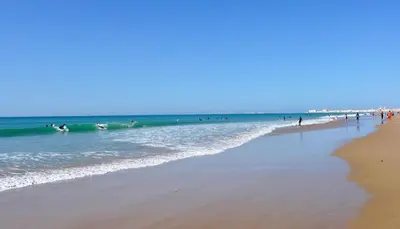 a group of people in the water at the beach at Sweet Velázquez Apto. zona Playa Victoria in Cádiz
