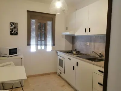 a kitchen with white cabinets and a sink and a window at Room in Lovely cottage house Habitaciones en Chalet en Cadiz San Fernando in San Fernando