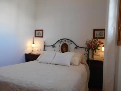 a bedroom with a white bed with two pillows at Apartamento Caracola in Chipiona