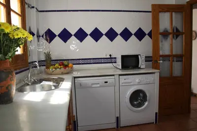 a kitchen with a washing machine and a sink at Apartamento Caracola in Chipiona