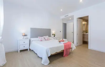 a white bedroom with a bed and a table at Luxe Vista Histórico 5 rooms 4 baños in Jerez de la Frontera