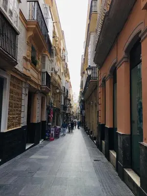 an alley with people walking down a street between buildings at Apartamentos Valverde Cádiz 1-B in Cádiz