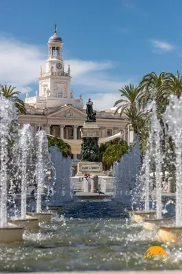 a fountain in front of a building with a clock tower at Apartamento Barrocal by Cadiz Time in Cádiz