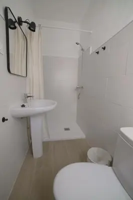 a white bathroom with a toilet and a sink at Amplio alojamiento con magnificas vista a 6 metros de la playa in Chipiona