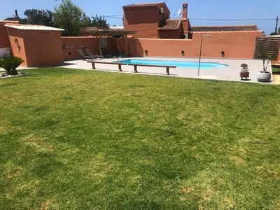 a backyard with a swimming pool and a grass yard at Apartamento con Piscina ADULTS ONLY in Chiclana de la Frontera