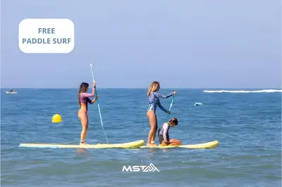 three girls are standing on surfboards in the ocean at Apartamento Vintage by Cadiz Time in Cádiz