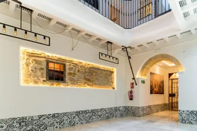 a room with a stone wall with a painting on the wall at Suite Capitán 1 in Cádiz