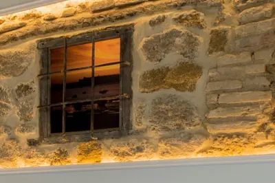 a window in a stone wall with a window grill at Fabio Catedral I in Cádiz