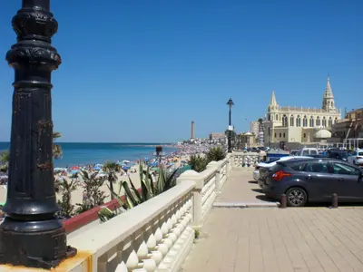 a black pole on a sidewalk next to a beach at 300-Meter-bis-zum-Strand-Caracola-Wohnung-mit-Garten in Chipiona