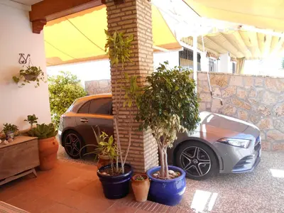 a car parked next to a building with potted plants at 300-Meter-bis-zum-Strand-Caracola-Wohnung-mit-Garten in Chipiona