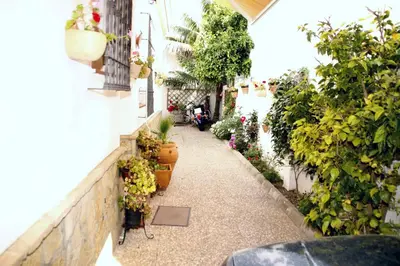 a garden corridor with potted plants on a building at 300-Meter-bis-zum-Strand-Caracola-Wohnung-mit-Garten in Chipiona