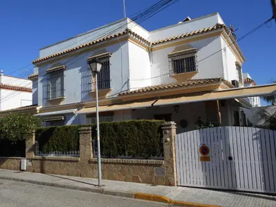 a white house with a fence in front of it at 300-Meter-bis-zum-Strand-Caracola-Wohnung-mit-Garten in Chipiona