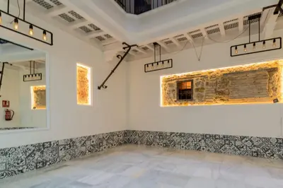 a room with a stone wall and a mirror at Apartamento Entrecatedrales in Cádiz
