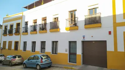 a building with cars parked in front of it at Sherryflat Jarana- Parking in Jerez de la Frontera