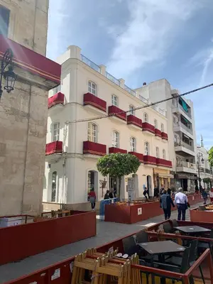 a building with tables and chairs in front of it at Casa Miguel - Apartamento 1 in Sanlúcar de Barrameda