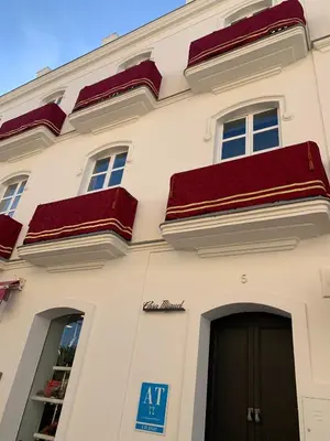 a white building with red roofs and a door at Casa Miguel - Apartamento 1 in Sanlúcar de Barrameda
