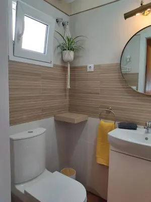 a bathroom with a toilet and a sink and a mirror at Apartamento la Capillita in Sanlúcar de Barrameda