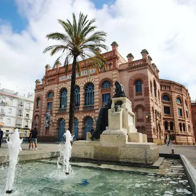 a fountain in front of a building with a statue at El Ático de Botica in Cádiz