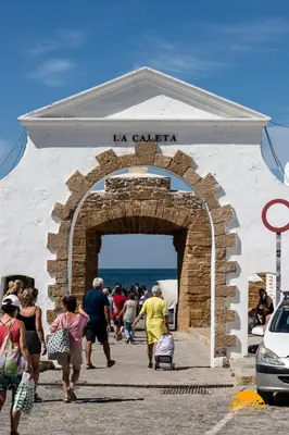 a group of people walking through a stone archway at Estudio Las Flores by Cadiz Time in Cádiz