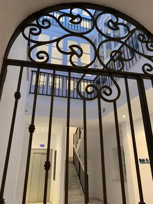 an iron gate with a staircase in a building at El 2 de Flamenco Ático 3ºA in Cádiz