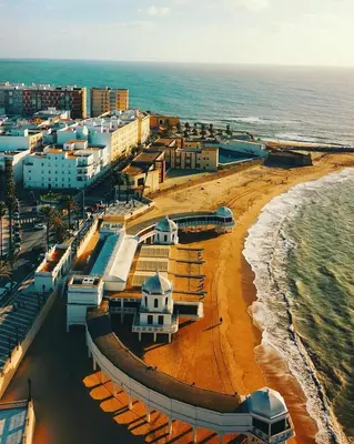 an aerial view of a beach with buildings and the ocean at El Patio de Santa María in Cádiz