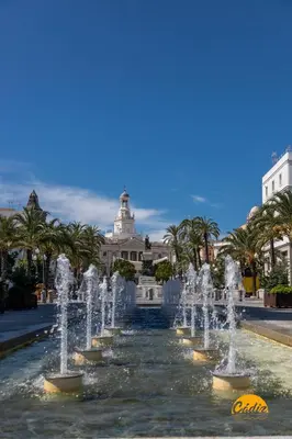 a fountain in front of a building with palm trees at Loft Santa María by Cadiz Time in Cádiz