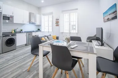 a kitchen and living room with a table and chairs at Estudio Al Sur de Cádiz in Cádiz