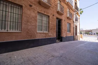 an empty street in front of a brick building at Allo Apartments San Roque 1ºC in Cádiz