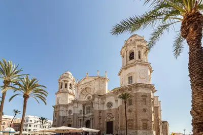 a church with palm trees in front of it at Allo Apartments San Roque 1ºC in Cádiz