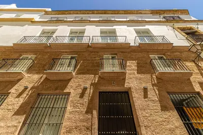 a tall brick building with windows and balconies at Allo Apartments San Roque 2ºA in Cádiz