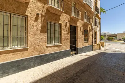an empty street in front of a brick building at Allo Apartments San Roque 2ºC in Cádiz