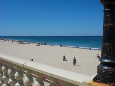 a view of a beach with people and the ocean at Penthouse Sleeps 4 with Private Garden in Chipiona