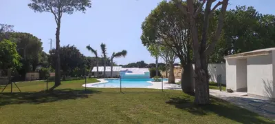 a large swimming pool in a park with trees at Hacienda Laguna Seca - Apart. Buganvilla in Chiclana de la Frontera