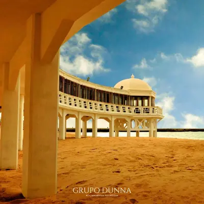 a building on the beach with a building in the sand at Apartamentos La Tahona Cádiz Centro in Cádiz