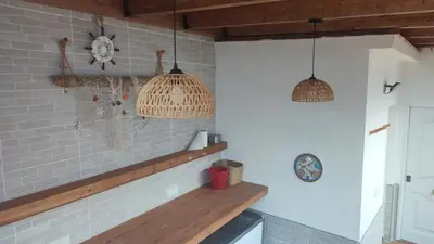 a kitchen with two pendant lights and a brick wall at Geranio Chipionahome in Chipiona