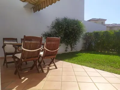 two chairs and a table on a patio at Villa Bosque Novo Sancti petri Grupo AC Gestión in Chiclana de la Frontera