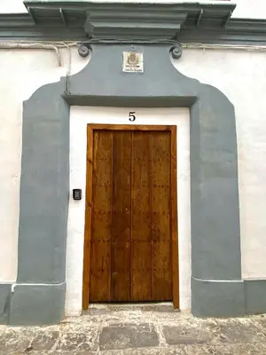 a wooden door with the number on the side of a building at Apartamento AstaRegia in Jerez de la Frontera